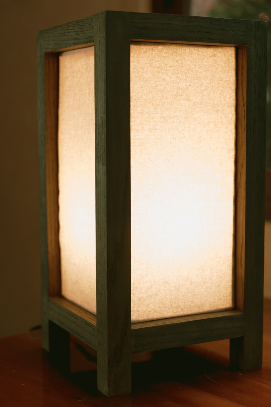 Lámpara de mesa de madera con pantalla translúcida encendida